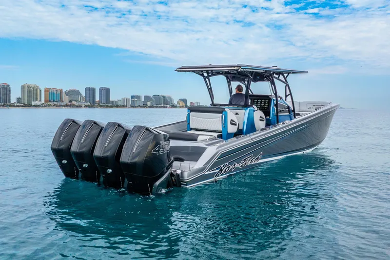 Slide: The Image of 2024 Nor-Tech 390 Sport Center Console boat with four engines on calm water. - 3