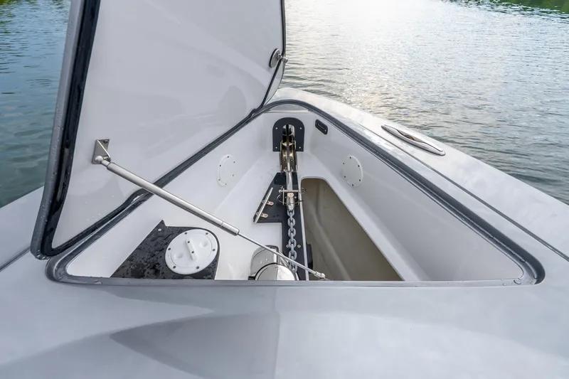 Slide: The Image of Open anchor compartment on 2024 Nor-Tech 390 Sport Center Console boat by the water. - 32