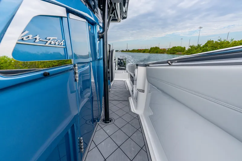 Slide: The Image of 2024 Nor-Tech 390 Sport Center Console boat, sleek blue exterior, cruising on a scenic waterway. - 36