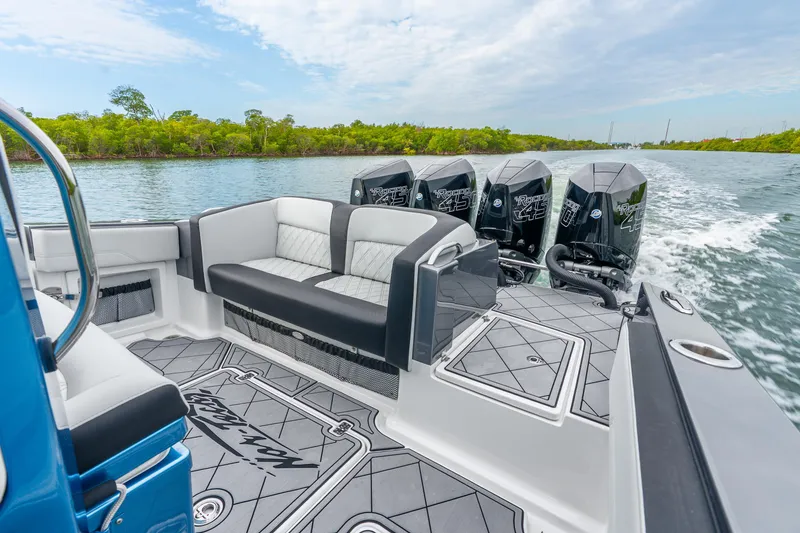 Slide: The Image of 2024 Nor-Tech 390 Sport Center Console cruising on a scenic waterway with powerful engines. - 37