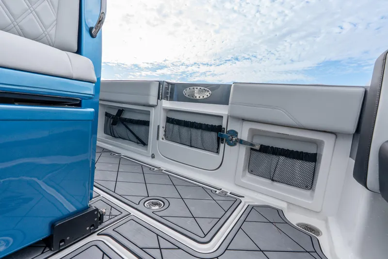 Slide: The Image of 2024 Nor-Tech 390 Sport Center Console interior with blue and gray seating, storage compartments. - 40