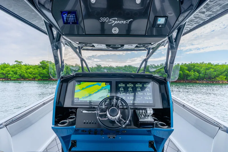 Slide: The Image of 2024 Nor-Tech 390 Sport Center Console dashboard with advanced navigation system on open water. - 50