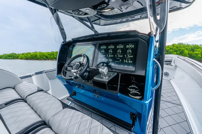 Slide: The Image of 2024 Nor-Tech 390 Sport Center Console helm with advanced navigation display and luxurious seating. - 51