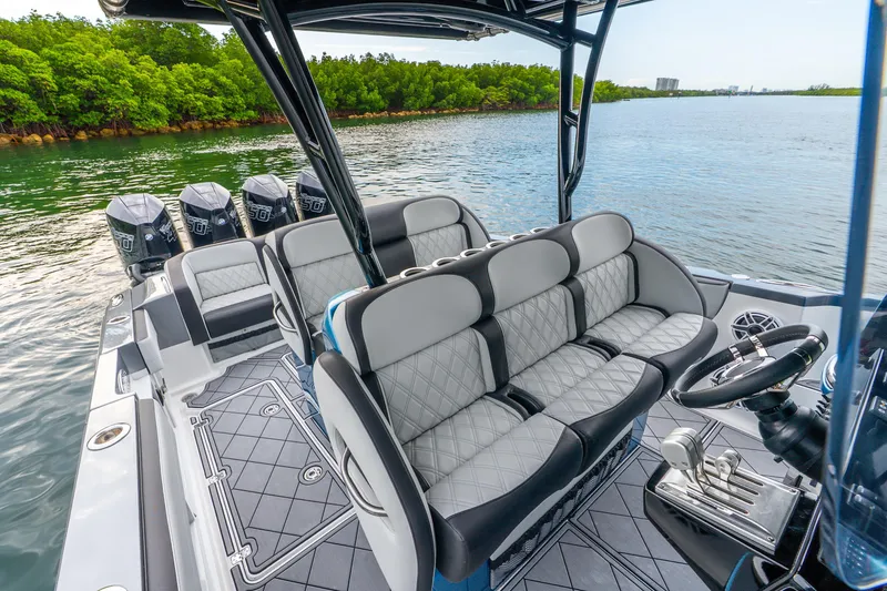 Slide: The Image of 2024 Nor-Tech 390 Sport Center Console boat interior with luxurious seating and multiple engines. - 52