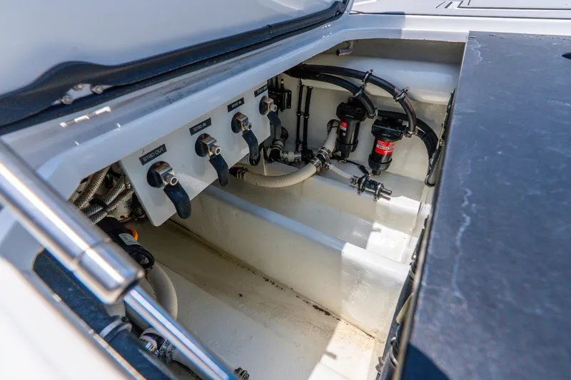 Slide: The Image of 2024 Nor-Tech 390 Sport Center Console engine compartment with labeled controls and hoses. - 53