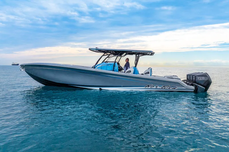 Slide: The Image of 2024 Nor-Tech 390 Sport Center Console boat on calm ocean waters under a blue sky. - 6