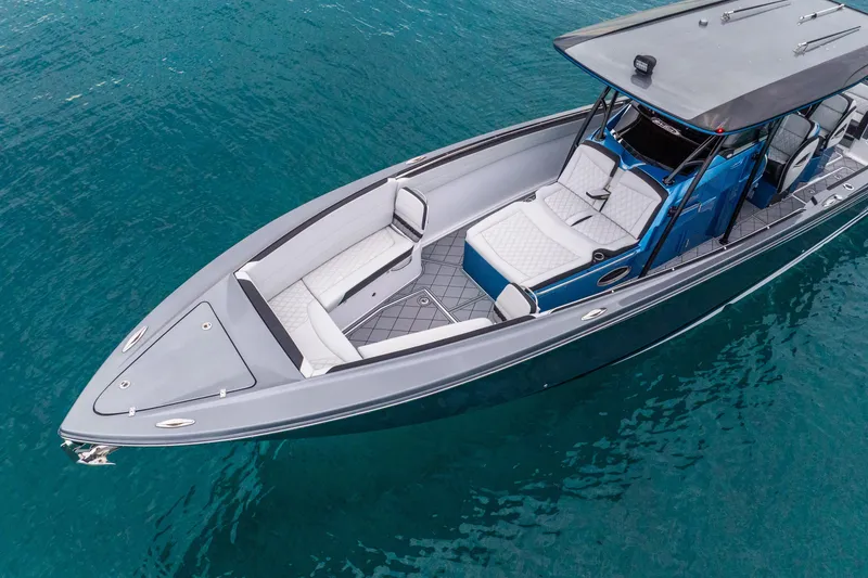 Slide: The Image of 2024 Nor-Tech 390 Sport Center Console boat on clear blue water. - 8