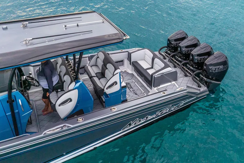 Slide: The Image of 2024 Nor-Tech 390 Sport Center Console boat with quad engines on turquoise water. - 9