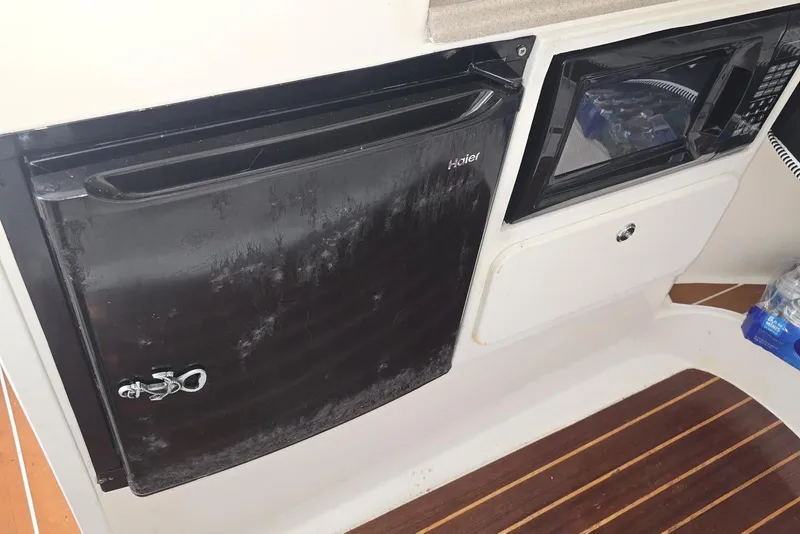 Slide: The Image of 2004 Stamas 290 Express interior with Haier fridge and microwave on wooden flooring. - 17