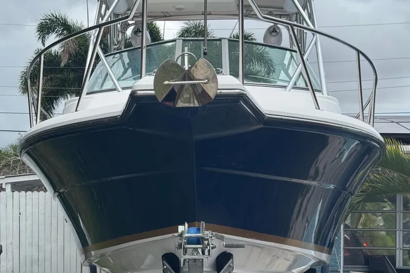 Slide: The Image of 2004 Stamas 290 Express boat with blue hull, docked outdoors. - 2