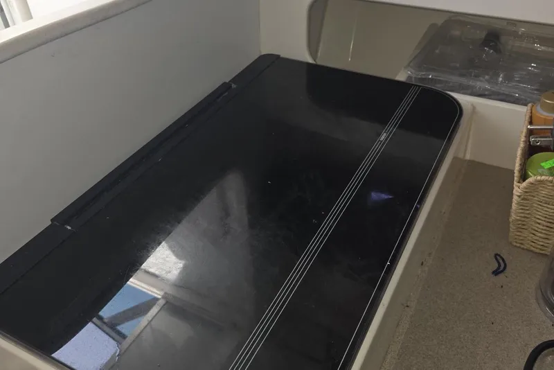 Slide: The Image of Interior of 2004 Stamas 290 Express boat with black countertop and storage basket. - 21