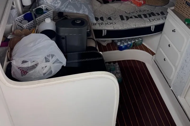 Slide: The Image of Interior of a 2004 Stamas 290 Express boat with fishing rods and cozy bedding. - 6