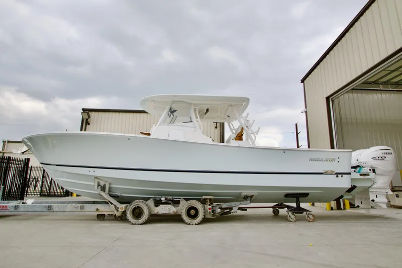 The Image of 2026 Regulator 37 boat on trailer, parked outside a warehouse under cloudy skies. - 0