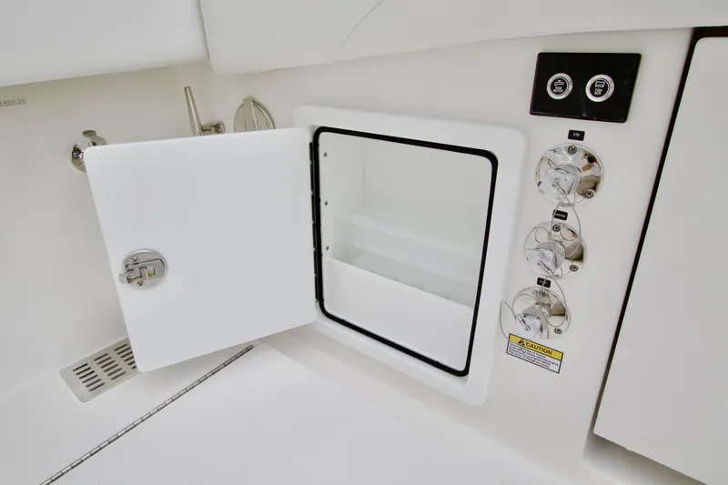 Slide: The Image of 2026 Regulator 37 boat storage compartment with open door and control panel. - 15