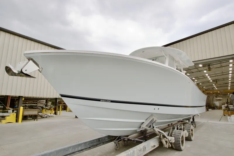 Slide: The Image of 2026 Regulator 37 boat on trailer outside a warehouse. - 2
