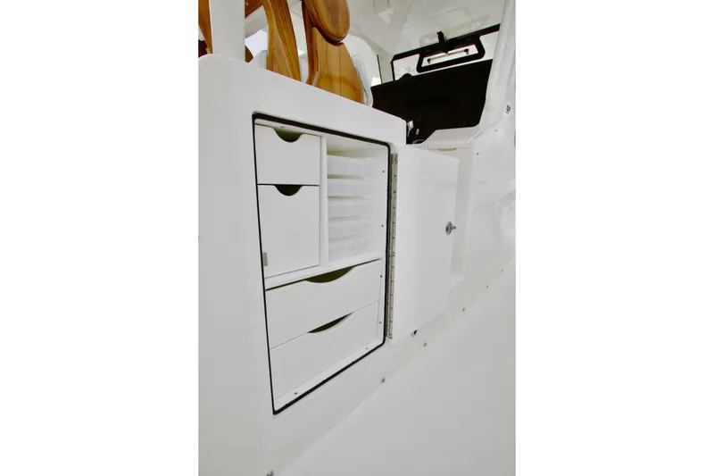 Slide: The Image of 2026 Regulator 37 boat interior storage compartment with open drawers and shelves. - 20