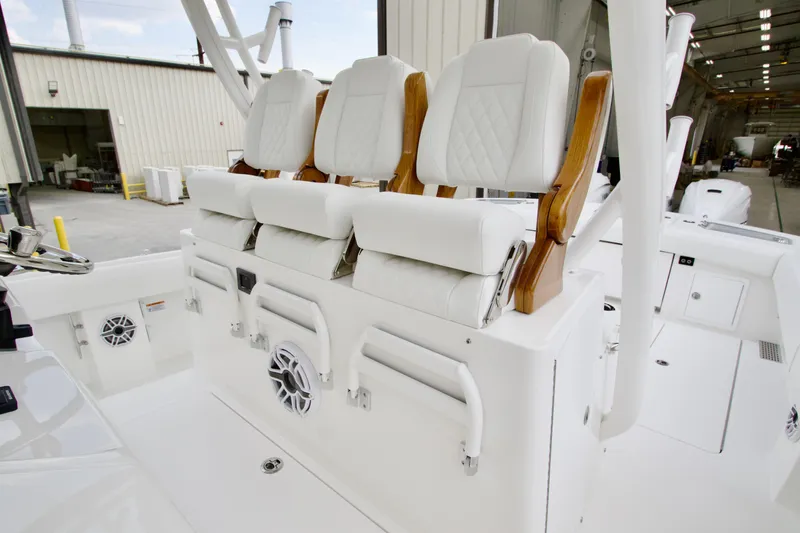 Slide: The Image of Luxury seating on 2026 Regulator 37 boat, featuring white cushioned chairs and wooden accents. - 24
