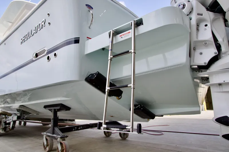 Slide: The Image of 2026 Regulator 37 boat with ladder and outboard motor in a marina setting. - 5