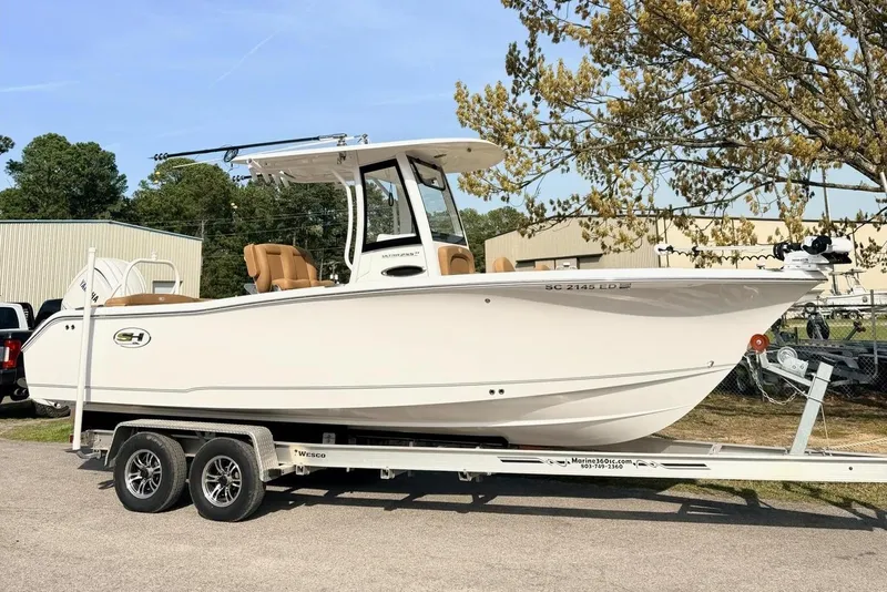 The Image of 2023 Sea Hunt Ultra 255 SE boat on trailer, parked outdoors under clear sky. - 0