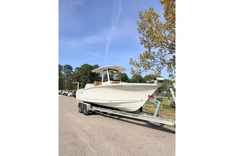 The Image of 2023 Sea Hunt Ultra 255 SE boat on trailer, parked outdoors under clear sky. - 1
