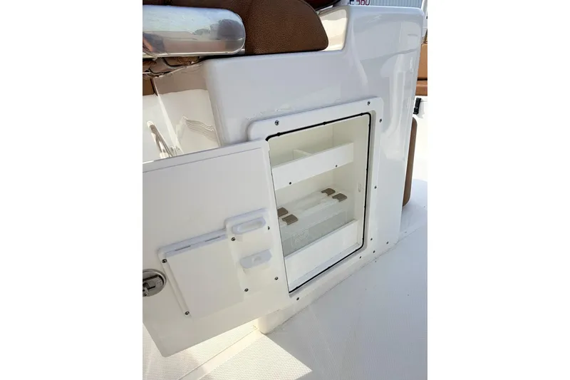 Slide: The Image of 2023 Sea Hunt Ultra 255 SE boat storage compartment with open door. - 12