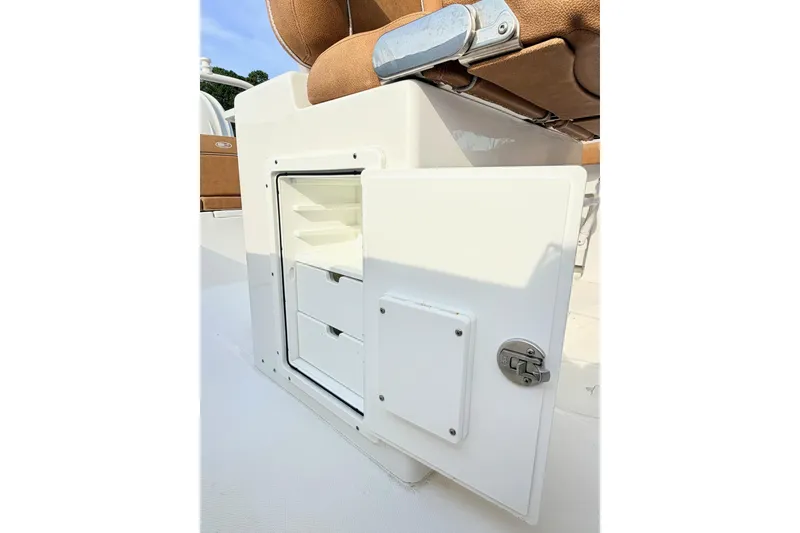Slide: The Image of 2023 Sea Hunt Ultra 255 SE boat storage compartment with drawers and cushioned seat. - 13