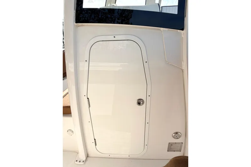 Slide: The Image of 2023 Sea Hunt Ultra 255 SE boat cabin door, sleek white design. - 17