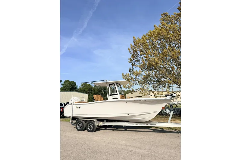 Slide: The Image of 2023 Sea Hunt Ultra 255 SE boat on trailer, parked outdoors under clear sky. - 3