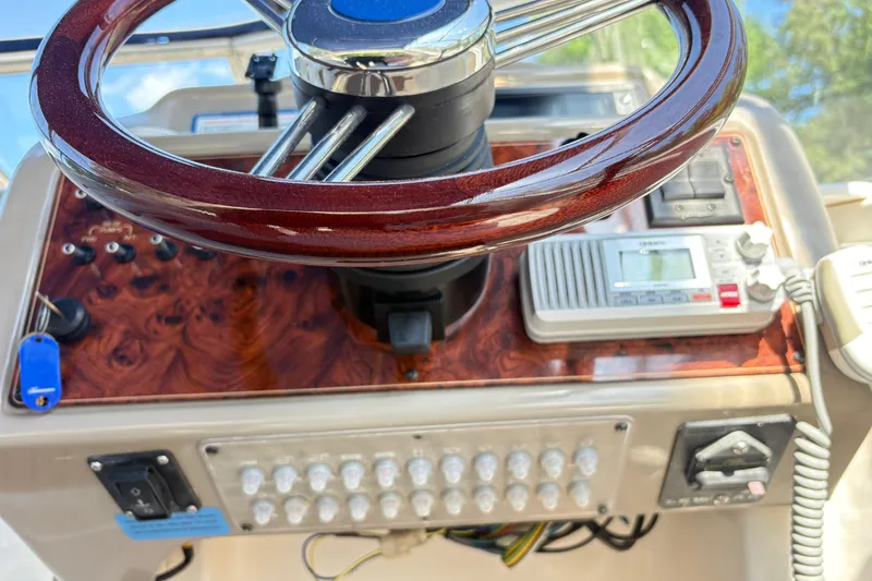 Slide: The Image of Steering wheel and controls of a 2003 Bayliner 285 Ciera boat cockpit. - 14