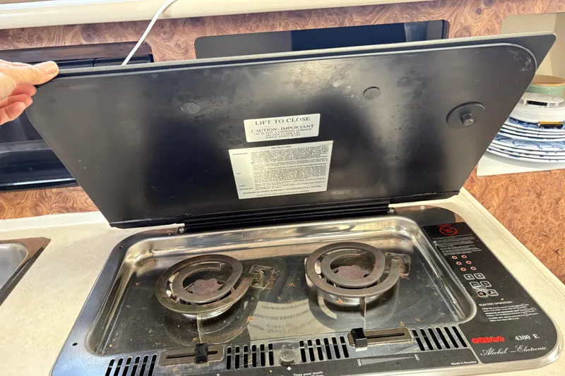 Slide: The Image of 2003 Bayliner 285 Ciera stove with open lid, revealing dual burners. - 18
