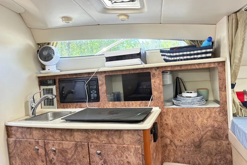 Slide: The Image of Interior of 2003 Bayliner 285 Ciera boat with kitchenette and storage shelves. - 19