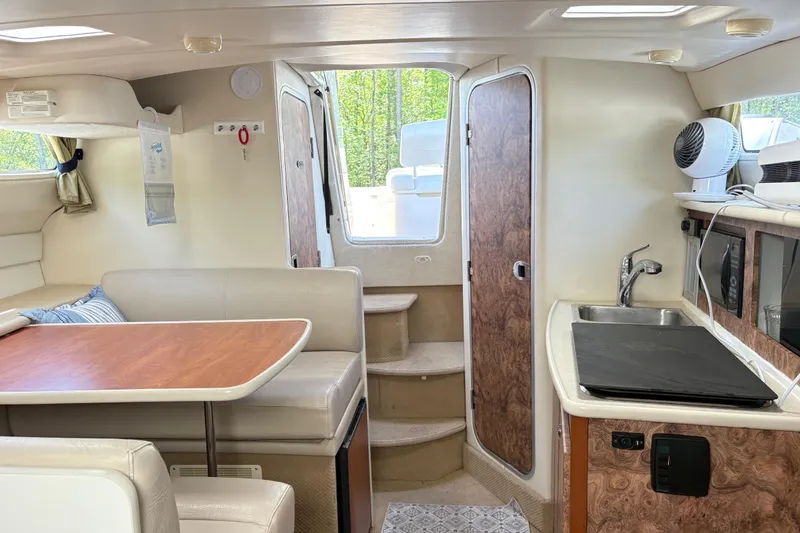 Slide: The Image of Interior of a 2003 Bayliner 285 Ciera boat with kitchenette and seating area. - 21