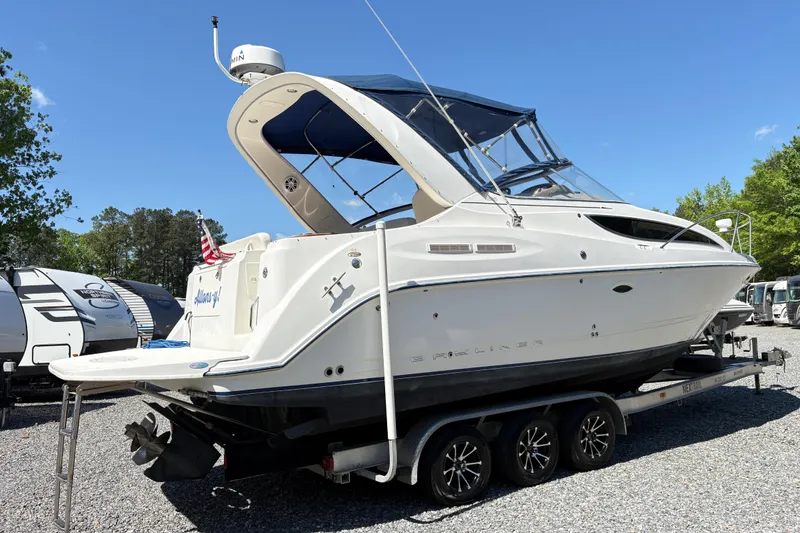 Slide: The Image of 2003 Bayliner 285 Ciera boat on trailer, parked outdoors under clear blue sky. - 3