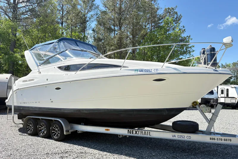 Slide: The Image of 2003 Bayliner 285 Ciera boat on trailer, parked outdoors with trees in background. - 4