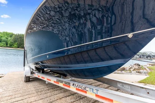 Slide: The Image of 2018 Sea Hunt Gamefish 27 boat on Magic Tilt trailer by a lake. - 6
