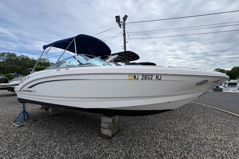 The Image of 2015 Chaparral 246 SSi boat with blue canopy on gravel lot, side view. - 0