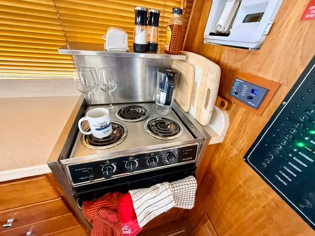 Slide: The Image of Kitchen area on a 2004 Mainship 400 Trawler with stove and utensils. - 9