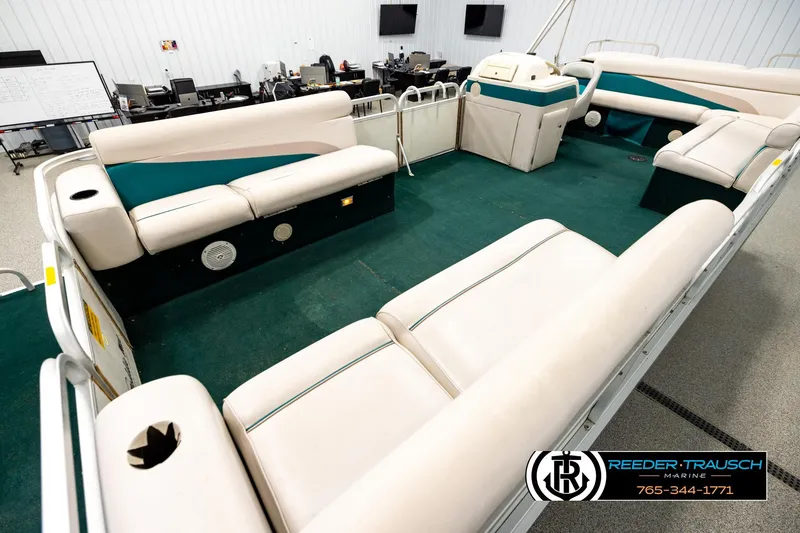 Slide: The Image of Interior of a 1998 Godfrey SW2423 pontoon boat with spacious seating and green carpet. - 10