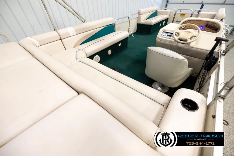 Slide: The Image of Interior of a 1998 Godfrey SW2423 pontoon boat with beige seating and green carpet. - 12