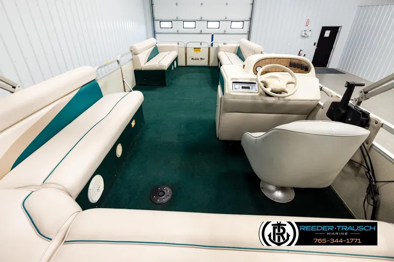 Slide: The Image of 1998 Godfrey SW2423 pontoon boat interior with green carpet and beige seating. - 16