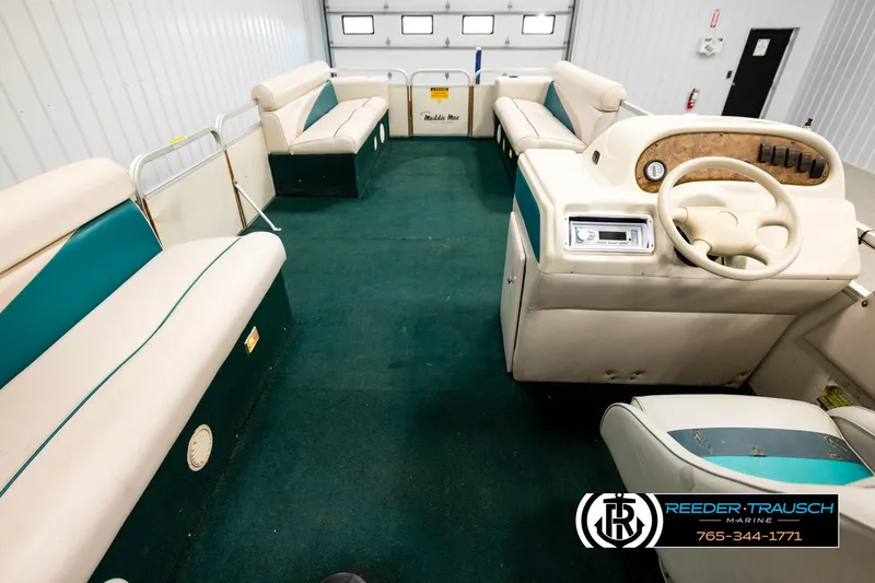 Slide: The Image of Interior of a 1998 Godfrey SW2423 pontoon boat with green carpet and beige seating. - 17