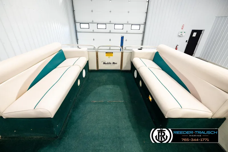 Slide: The Image of Interior of a 1998 Godfrey SW2423 boat with beige seating and green accents. - 18