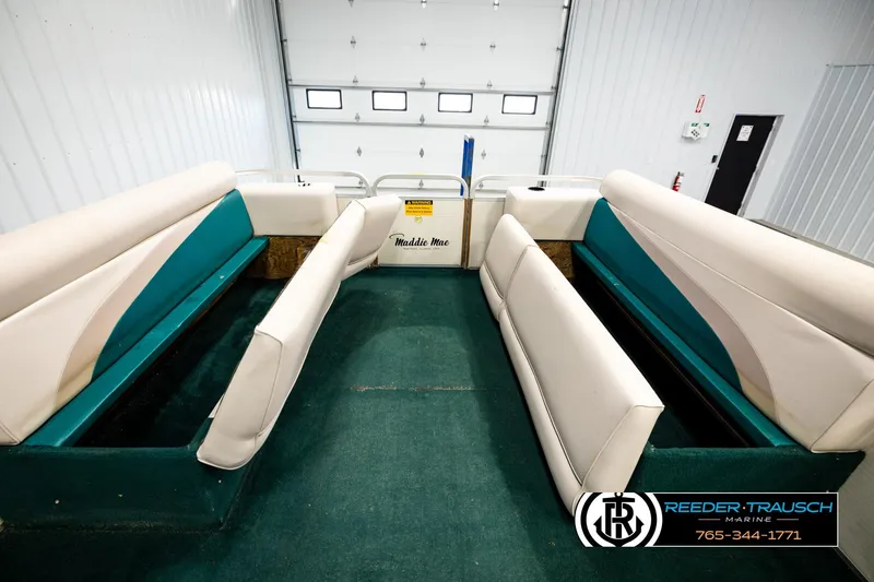 Slide: The Image of Interior of a 1998 Godfrey SW2423 boat with teal and cream seating. - 19