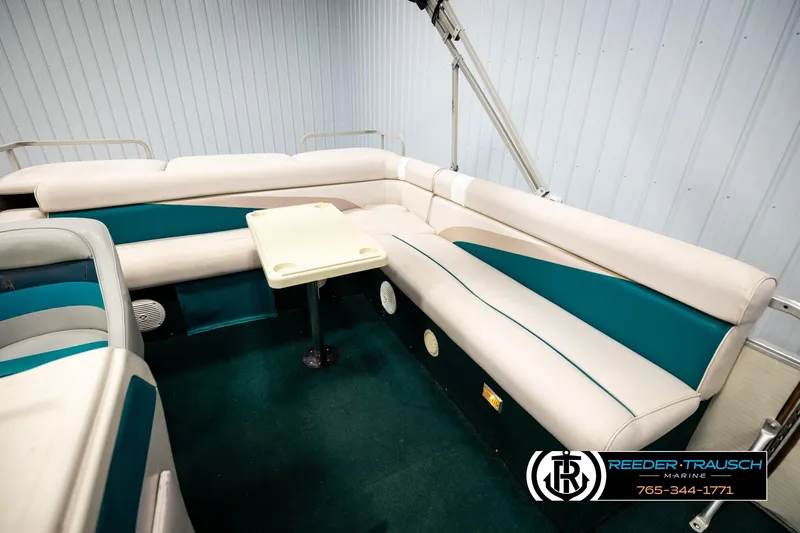 Slide: The Image of Interior of a 1998 Godfrey SW2423 boat with teal and white seating. - 20