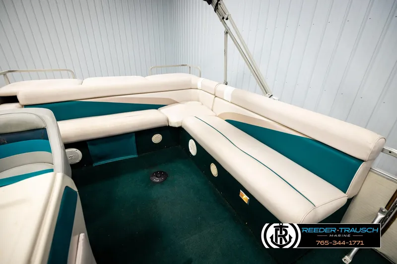 Slide: The Image of Interior of a 1998 Godfrey SW2423 boat with teal and white seating. - 21
