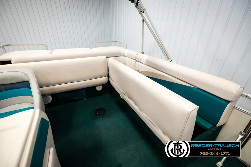 Slide: The Image of Interior of a 1998 Godfrey SW2423 boat with beige seating and teal accents. - 22