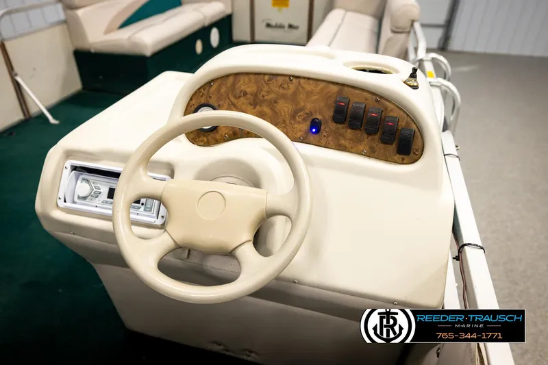 Slide: The Image of 1998 Godfrey SW2423 boat dashboard with steering wheel and control panel. - 23