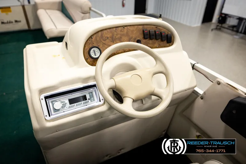 Slide: The Image of Steering console of a 1998 Godfrey SW2423 boat with control panel and stereo system. - 24