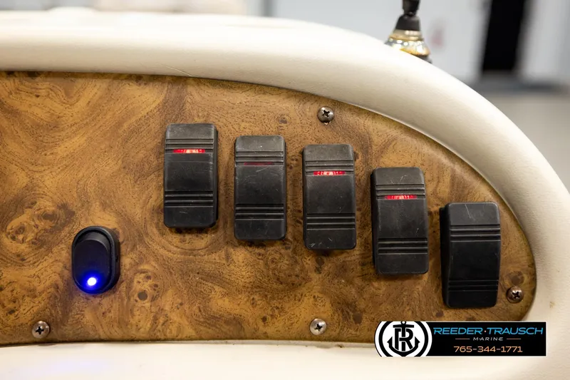 Slide: The Image of Control panel of a 1998 Godfrey SW2423 boat with switches and a blue indicator light. - 27