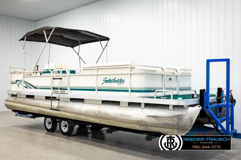Slide: The Image of 1998 Godfrey SW2423 pontoon boat on trailer in indoor storage facility. - 3